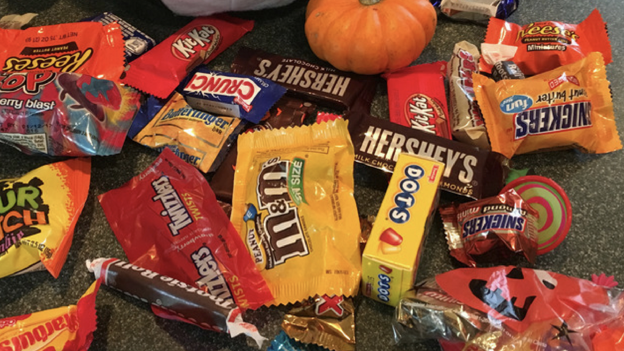 Nineteenth Sunday after Pentecost — October 4, 2026 8 Close-up of a heaped pile of assorted wrapped Halloween candy bars with a small orange pumpkin among them.